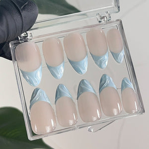 A set of ten false nails in a clear plastic case. The nails are oval shaped and have a light pink base with a light blue design on the tips.