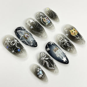 Set of ten black and white ombre nail tips with silver glitter and cat illustrations. Each nail tip features a different cat design.