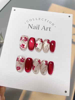 A set of ten red and white nail art tips with a floral design. The tips are arranged in two rows of five. The tips are on a white card with the text "COLLECTION Nail Art."