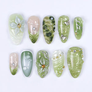 Handmade green press-on nails featuring 3D floral accents, metallic butterflies, and marble effects — perfect for spring events, garden parties, or a thoughtful gift for her.