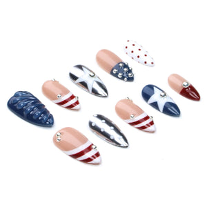 A set of ten almond-shaped press-on nails featuring a patriotic theme with red, white, and blue colors. Designs include stripes, stars, polka dots, and solid navy blue with textured ridges, accented with small silver metallic studs.