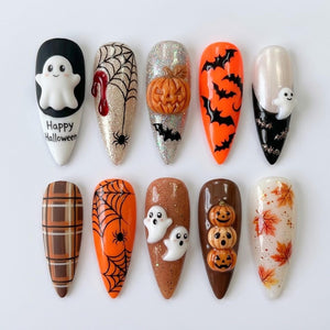 Ten almond-shaped press-on nails featuring Halloween designs including a white ghost with the text Happy Halloween, spider webs, a 3D pumpkin, black bats on orange, a small ghost, brown plaid, a spider, two ghosts, three pumpkins, and leaves.