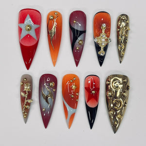 Ten different nail art designs on long, almond-shaped nails. The designs include a star, a rose, a crescent moon, a cross, a bird, a geometric pattern, a red star, a gold crescent moon, and a gold star.