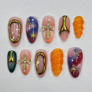Ten different nail designs featuring a variety of colors, patterns, and embellishments, including gold crosses, swirls, and stars.