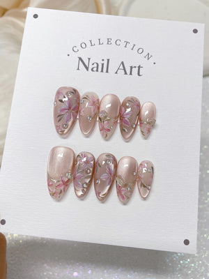 A set of ten pink and white nail tips with floral designs and rhinestones. The nail tips are displayed on a white card with the text "COLLECTION. Nail Art."