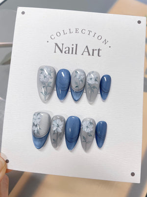 A set of ten fake nails with a blue and white floral design. The nails are displayed on a white card with the text "COLLECTION. Nail Art."