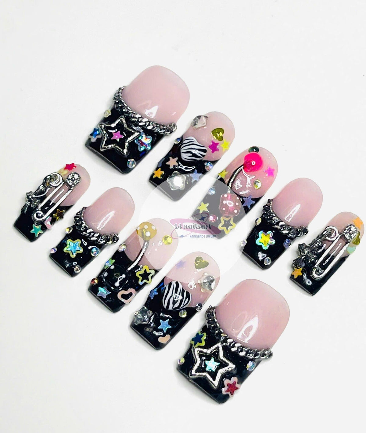 Set of ten black and pink press-on nails with various colorful designs, including stars, hearts, chains, and a safety pin.