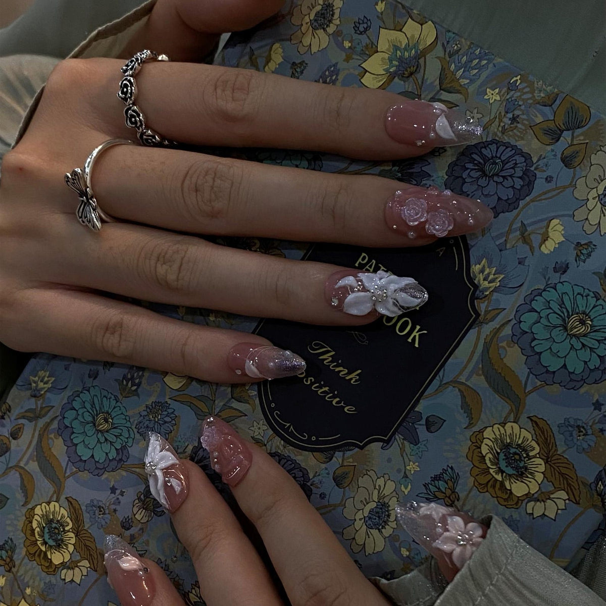 3D bridal press on nails with nude pink base, sculpted white florals, glittery silver ombré tips, and rhinestone accents — luxury wedding nails for bride, custom handmade fake nails, elegant and timel