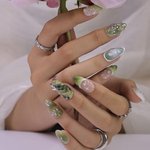 Handmade green press-on nails featuring 3D floral accents, metallic butterflies, and marble effects — perfect for spring events, garden parties, or a thoughtful gift for her.