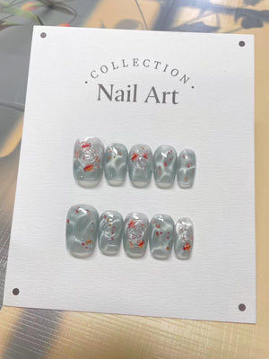 A set of ten light blue press-on nails with a white floral design and red accents. The nails are displayed on a white card with the text "COLLECTION. Nail Art."