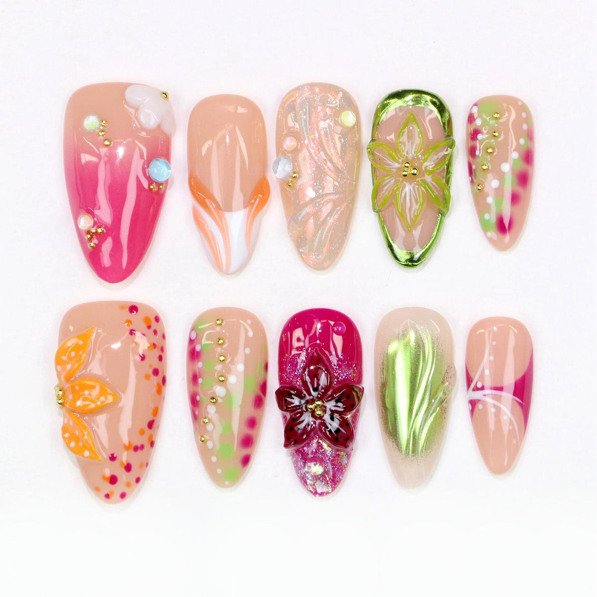 A collection of ten almond-shaped artificial nails with various designs. The nails feature a range of colors, including pink, orange, green, and nude, with embellishments like flowers, dots, and glitter. Some nails have a glossy finish, while others 