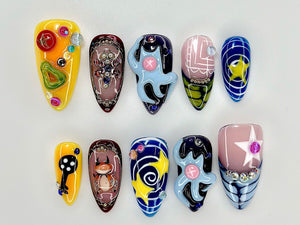 A set of ten artificial nails with various designs. The nails feature a range of colors, including yellow, blue, pink, and brown, with decorative elements such as stars, swirls, and abstract shapes. Some nails have 3D embellishments.
