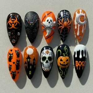 A set of ten Halloween-themed artificial nails. Designs include a biohazard symbol, a bat, a ghost with chains, a spider on a web, a crescent moon, black cats, a haunted house, a sugar skull, a jack-o'-lantern, and the word "BOO!"