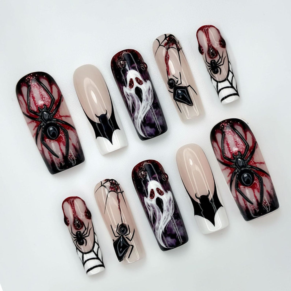 A set of ten coffin-shaped press-on nails with Halloween-themed designs. The designs include spiders, spiderwebs, ghosts, and bat wing tips. The nails feature a mix of colors, including black, red, white, and nude.