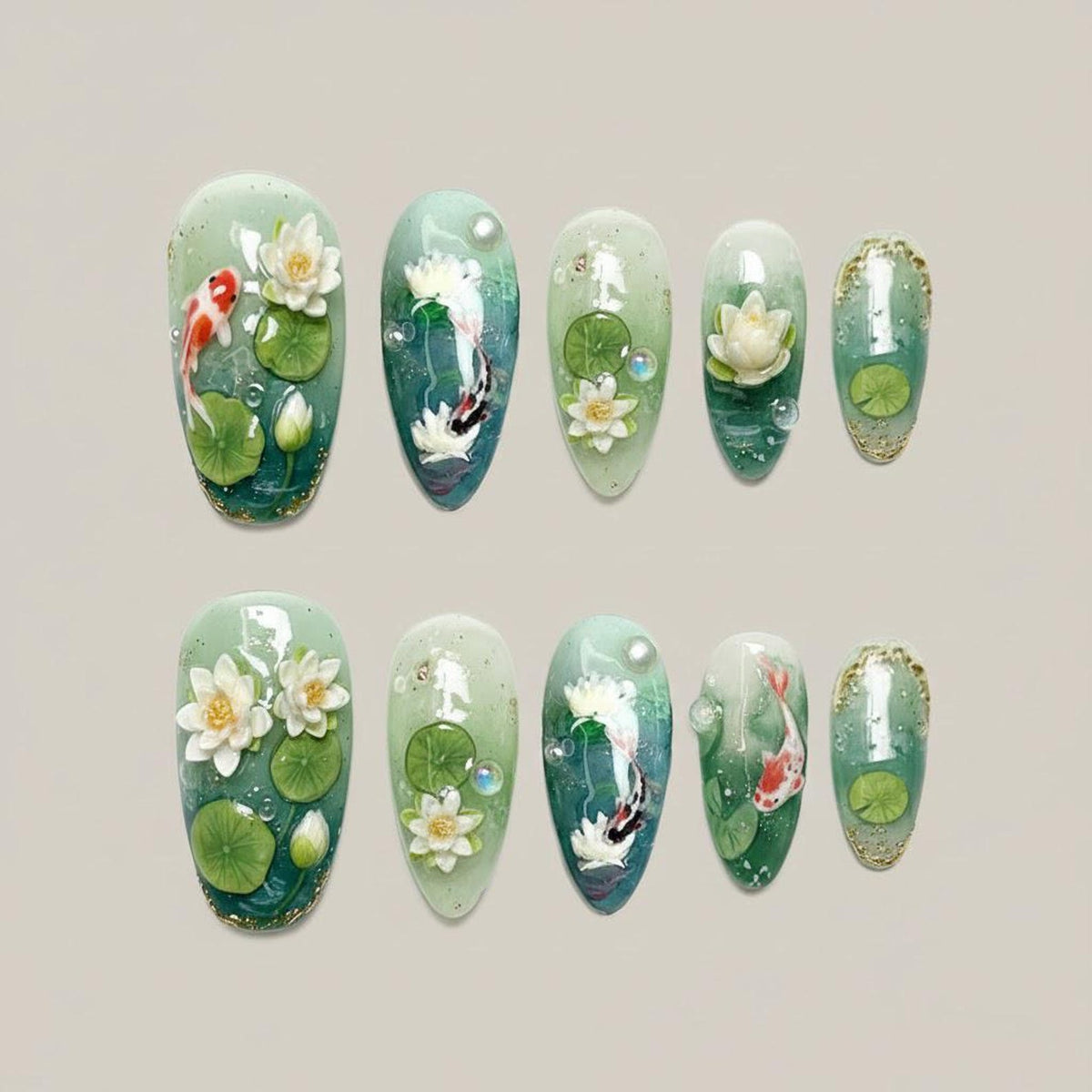 A set of ten almond-shaped artificial nails with a water lily and koi pond design. The nails feature a gradient of green and blue, with 3D white water lilies, green lily pads, and orange and black koi fish.