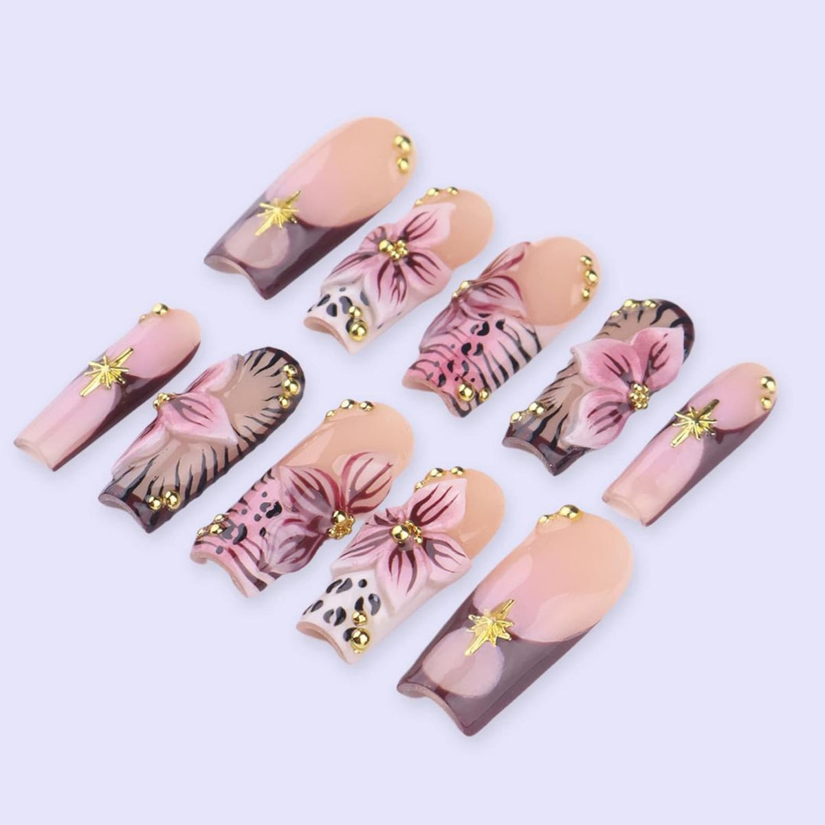 A collection of ten artificial nails with a variety of designs. The nails feature a combination of light pink, brown, and gold accents. Some nails have floral designs, while others have gold star embellishments.