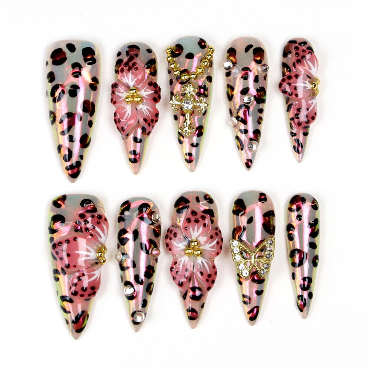 A set of ten long, pointed artificial nails. Each nail features a pink and brown leopard print design. Some nails are adorned with 3D pink flowers, gold accents, and rhinestones. One nail has a gold butterfly.