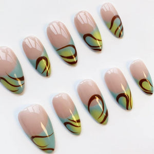 Set of artificial nails with a nude base, a light blue and yellow gradient, and a dark brown swirl design. The nails are oval-shaped and arranged on a white surface.