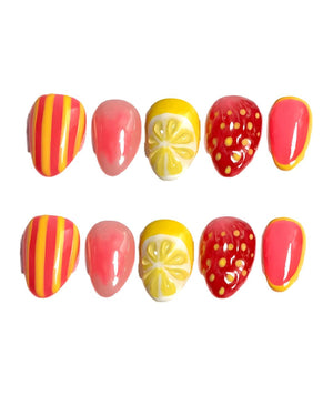 A set of ten press-on nails with a fruit theme. Designs include yellow and orange striped nails, solid pink nails, lemon slice nails, strawberry nails, and pink nails with yellow borders. The nails ar