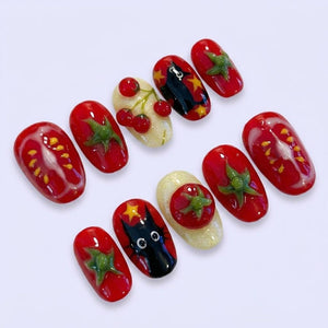 A set of ten artificial nails with a variety of designs. The nails feature a red tomato theme, with some nails showcasing tomato slices, green leaves, and cherry designs. Other nails have a black cat design.