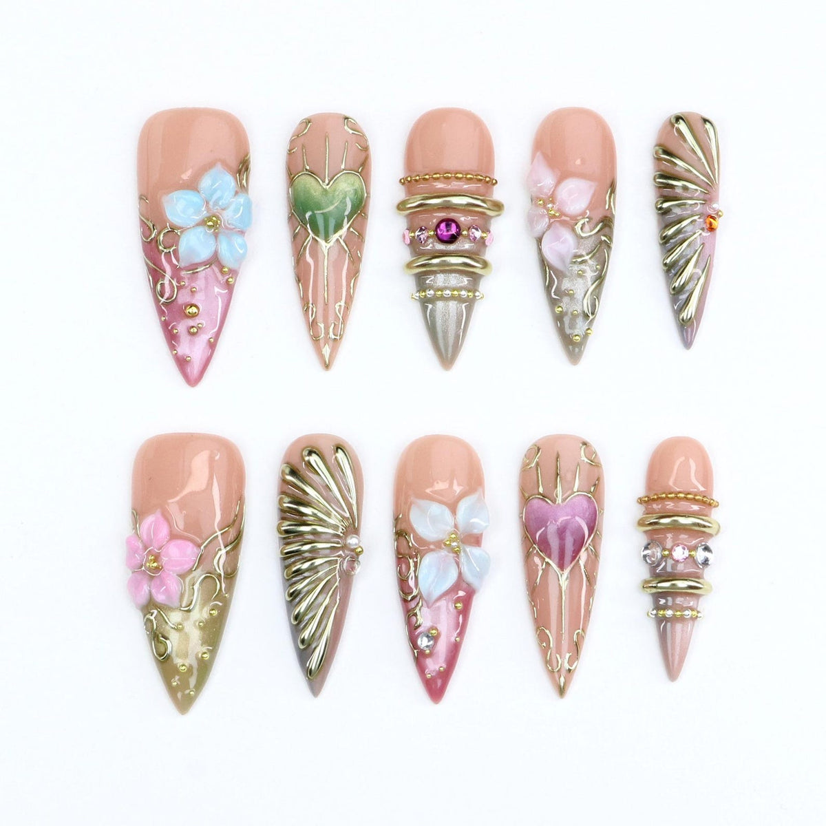 A set of ten stiletto-shaped press-on nails featuring a nude base with intricate 3D embellishments. Designs include raised light blue and pink flowers, metallic gold filigree, heart motifs, stacked gold rings, and small rhinestones.
