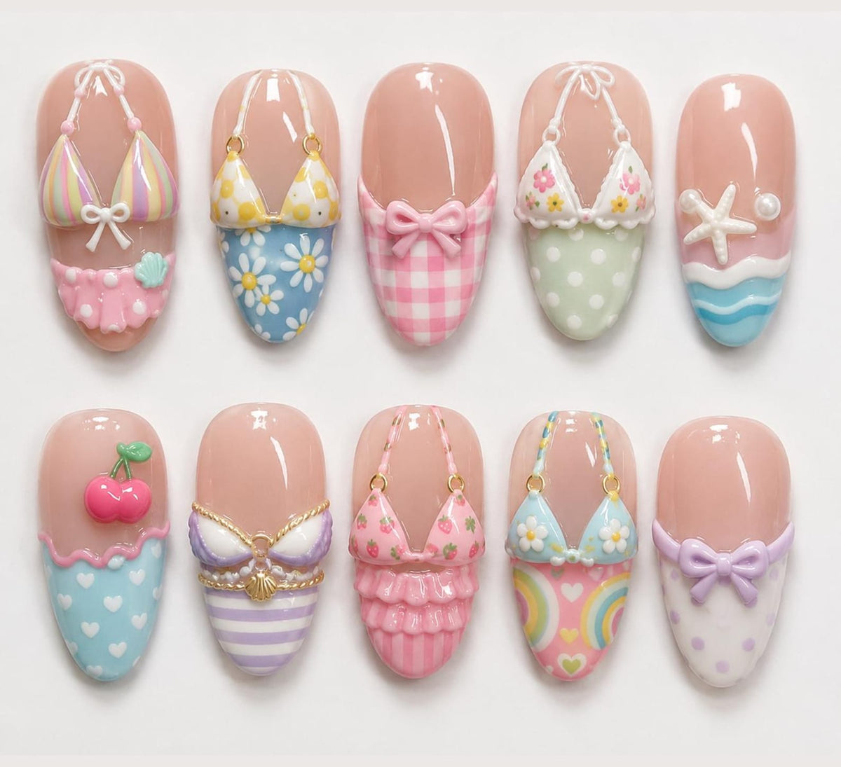 A set of ten press-on nails featuring 3D designs including bikinis with floral, striped, and gingham patterns, a starfish, cherries, and bows. The nails have a glossy finish with various pastel colors like pink, blue, and yellow.