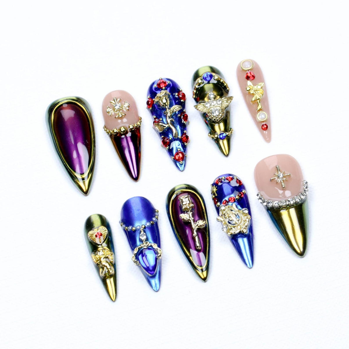 A set of ten stiletto-shaped press-on nails featuring metallic purple, blue, and gold finishes. The designs include gold rose emblems, red rhinestones, clear crystals, and star-shaped charms on a mix of solid and nude-base nails.