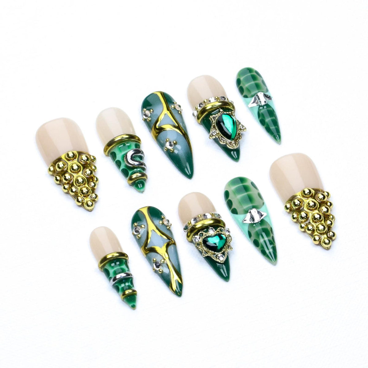 A set of ten press-on nails featuring a nude base and a pointed green tip with a crocodile skin pattern. The nails are decorated with gold metal accents, small clear rhinestones, and green heart-shaped or star-shaped gems.