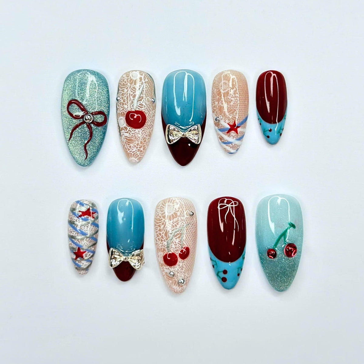 Handmade cherry beach press on nails in sky blue, cherry red, and nude featuring coquette bows, starfish accents, lace details, glossy finish, and playful coastal summer aesthetic.