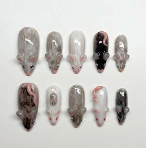 A set of ten press-on nails featuring hand-painted mouse designs in various colors including white, gray, brown, and black. Each nail displays a detailed mouse figure with small ears, eyes, and tails, showcasing a glossy finish.