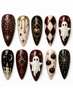 A set of ten stiletto-shaped press-on nails featuring Halloween-themed designs in black, cream, and deep burgundy. The nails are decorated with raised 3D elements including white ghosts, gold spiderwebs, pumpkins, candles, and stars.