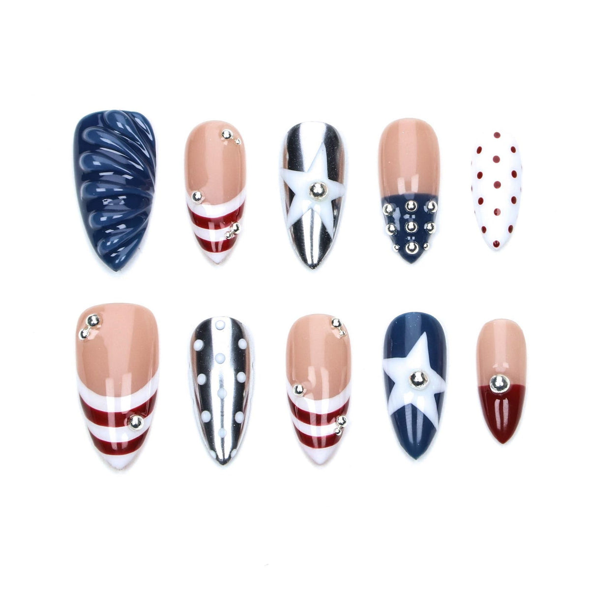 A set of ten almond-shaped press-on nails featuring patriotic designs in red, white, and blue. The collection includes textured navy blue, striped patterns, white stars, silver metallic accents, red polka dots, and small silver studs.