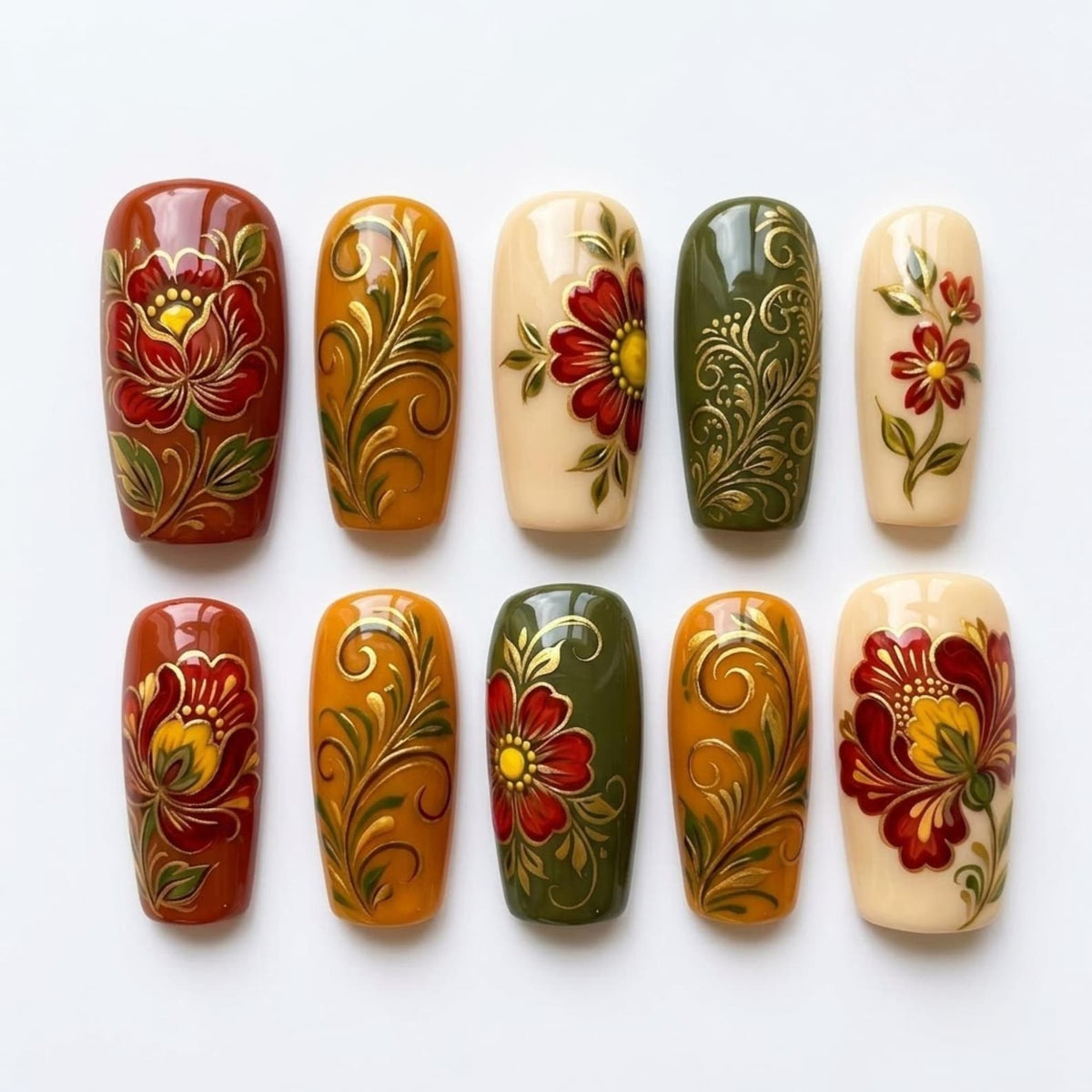 A set of ten press-on nails featuring intricate hand-painted floral designs and golden filigree swirls. The color palette includes deep red, mustard yellow, olive green, and cream, with glossy finishes on each rectangular nail tip.