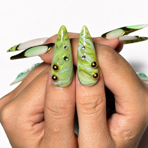 Green marble press on nails with botanical leaf art, 3D white flowers, gold chrome accents, pearl embellishments, and glossy square shape