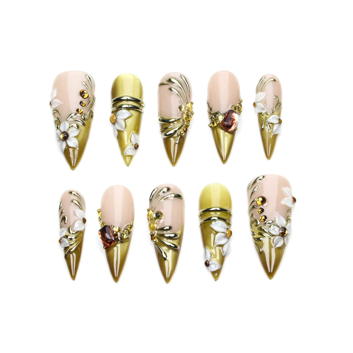 A set of ten stiletto-shaped press-on nails featuring a gradient of nude and olive green. The nails are decorated with raised white floral accents, metallic gold swirls, and small amber-colored rhinestones arranged in various patterns.
