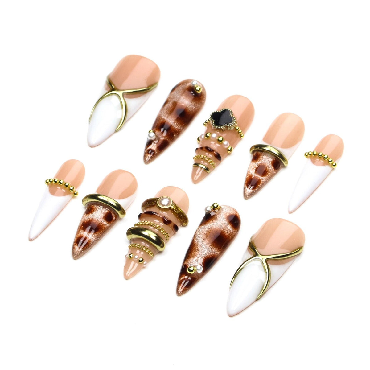 A set of ten stiletto-shaped press-on nails featuring a mix of nude, white, and brown leopard print designs. The nails are decorated with gold-toned metal rings, chains, small white pearls, and a black clover-shaped charm accent.
