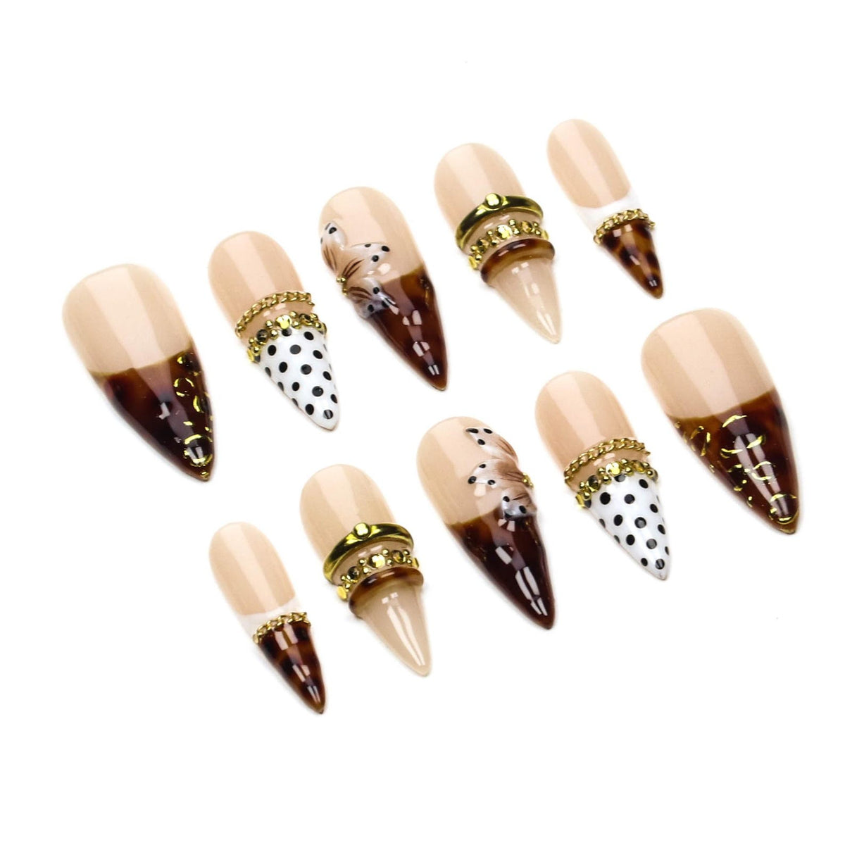 A set of ten stiletto-shaped press-on nails featuring a nude base with varied designs including brown tortoiseshell patterns, black polka dots on white, and gold-toned metallic chain accents applied across the surface of the nails.