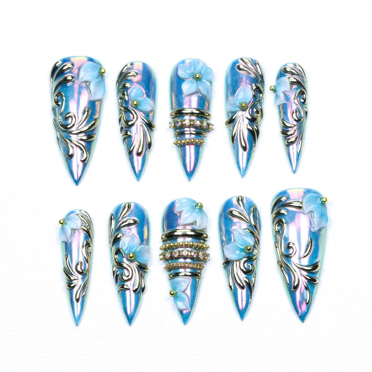 A set of ten stiletto-shaped press-on nails featuring an iridescent light blue base. Each nail is decorated with raised silver filigree patterns, small light blue floral accents, and some include horizontal bands of tiny clear rhinestones.