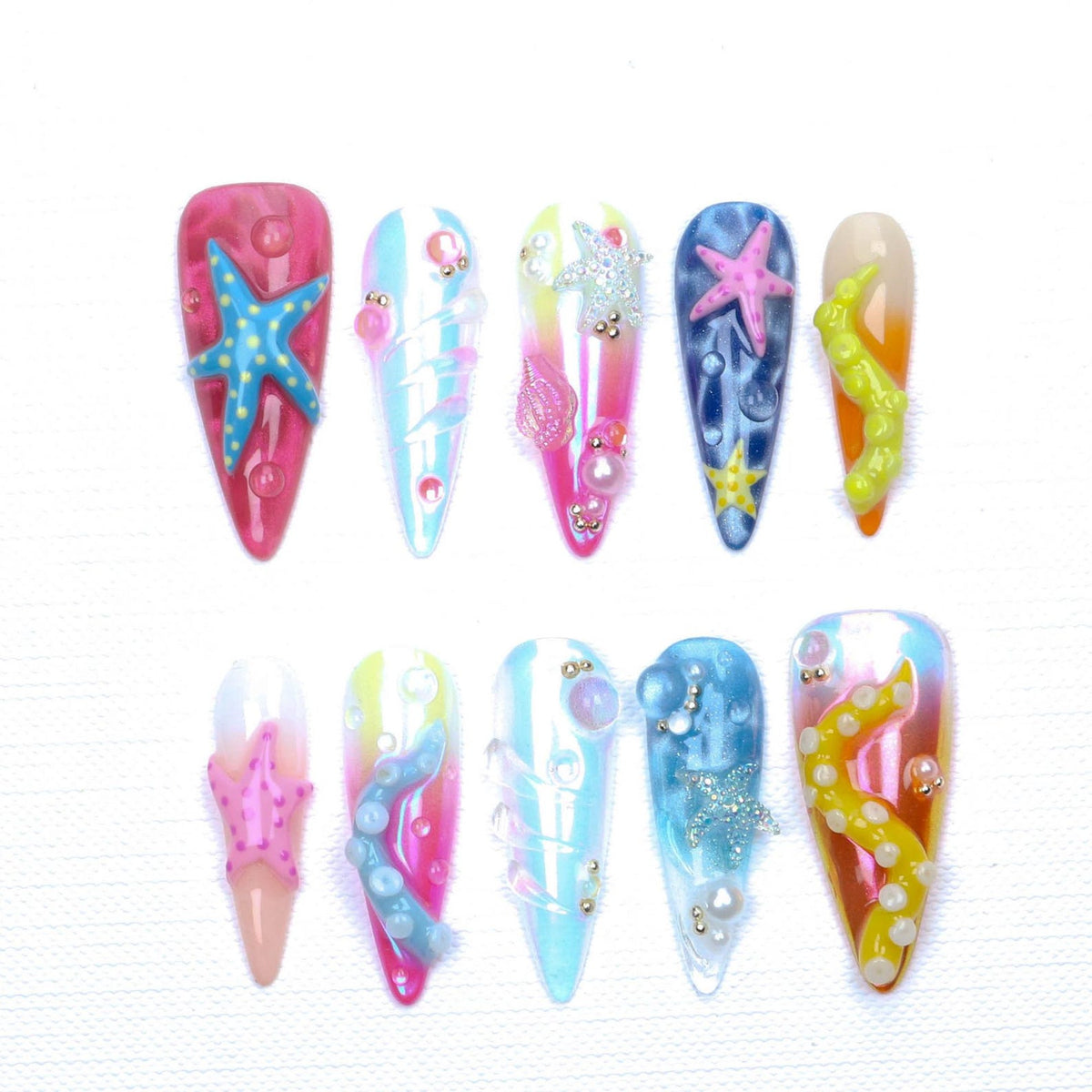 A set of ten press-on nails featuring an ocean theme with almond-shaped tips. The designs include gradient colors, 3D starfish, tentacles, and small pearls. The nails display various shades of pink, blue, yellow, and white with glossy finishes and te
