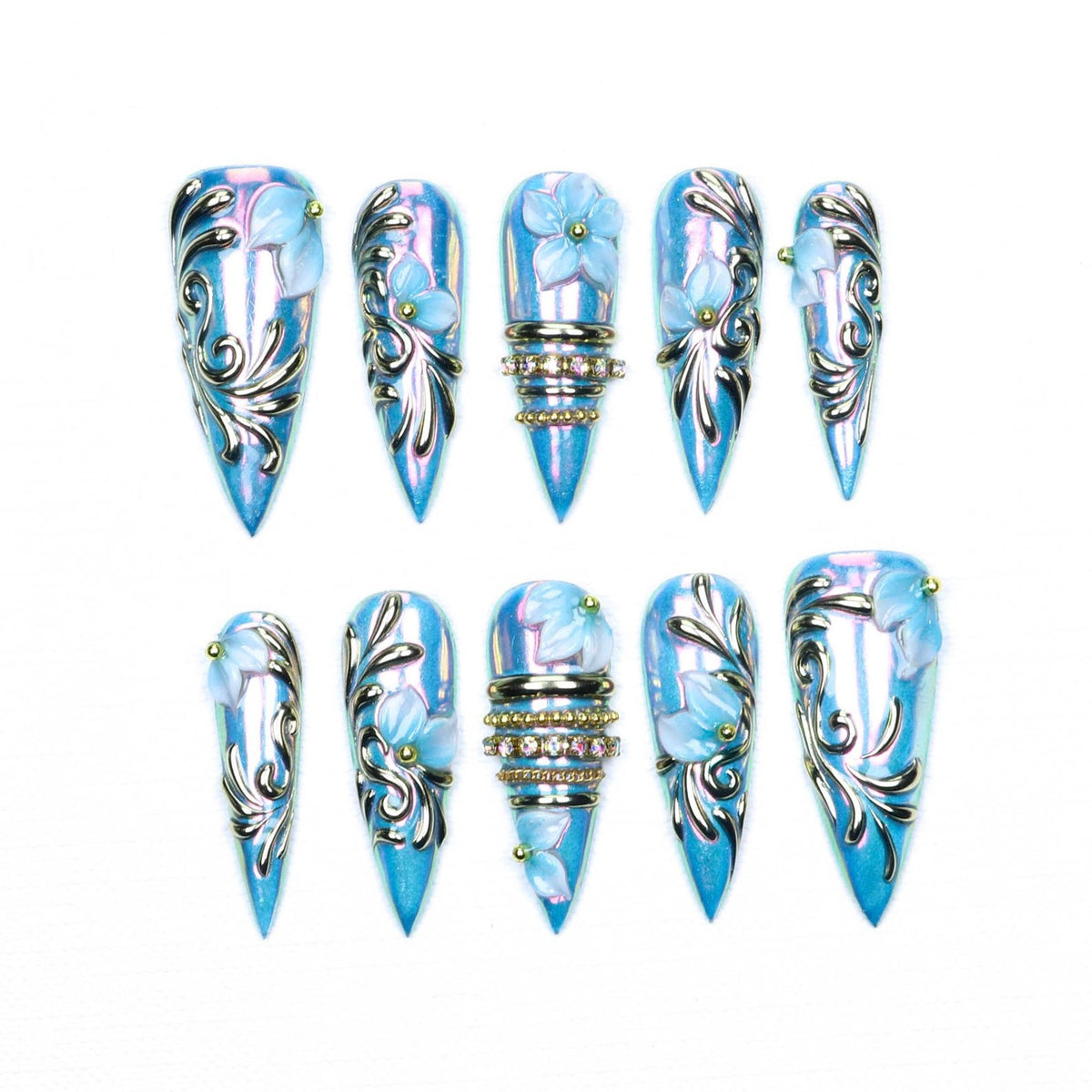 A set of ten stiletto-shaped press-on nails featuring a metallic light blue iridescent finish. The nails are decorated with raised silver filigree swirls, three-dimensional light blue flower accents, and rows of small clear rhinestones.