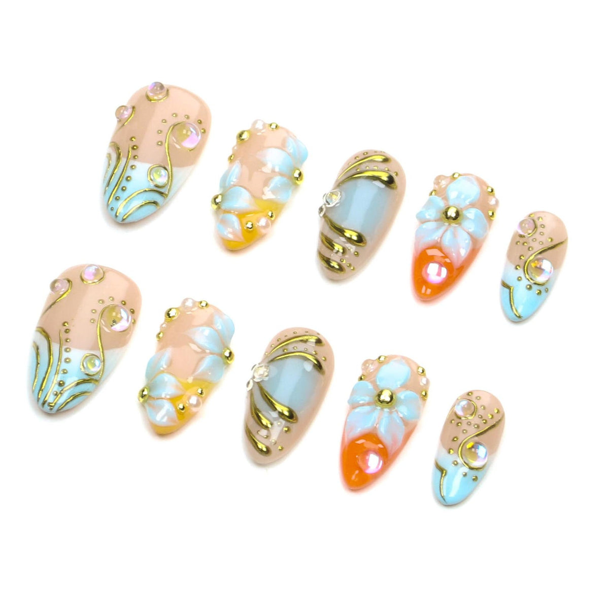 A set of ten press-on nails featuring a mix of nude, light blue, and orange base colors. The designs include raised white floral petals, gold metallic swirls, and small iridescent rhinestones arranged in various decorative patterns.