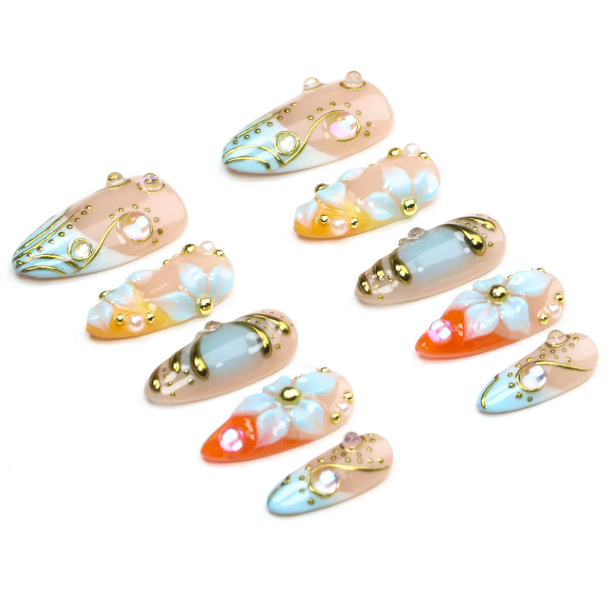 A set of ten almond-shaped press-on nails featuring a variety of designs including light blue, orange, and nude gradients, white floral accents, gold metallic line detailing, and small embedded iridescent rhinestones and pearls.