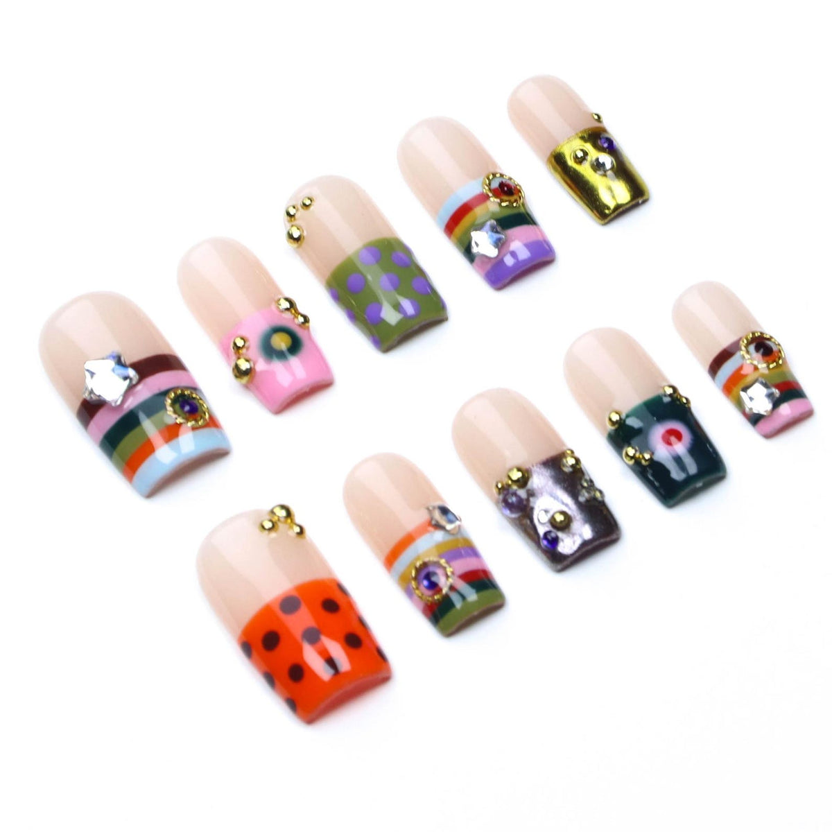 A set of ten press-on nails featuring a nude base with various decorative designs including horizontal stripes, polka dots, and solid colors. Each nail is embellished with small gold-toned metal beads and colorful rhinestones.
