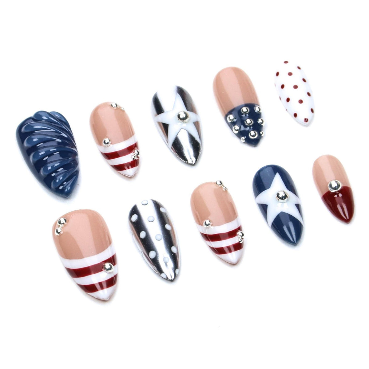 A set of ten almond-shaped press-on nails featuring a patriotic theme. Designs include navy blue with ridges, nude bases with red and white stripes, silver with white stars, navy blue with silver studs, and white with red polka dots.