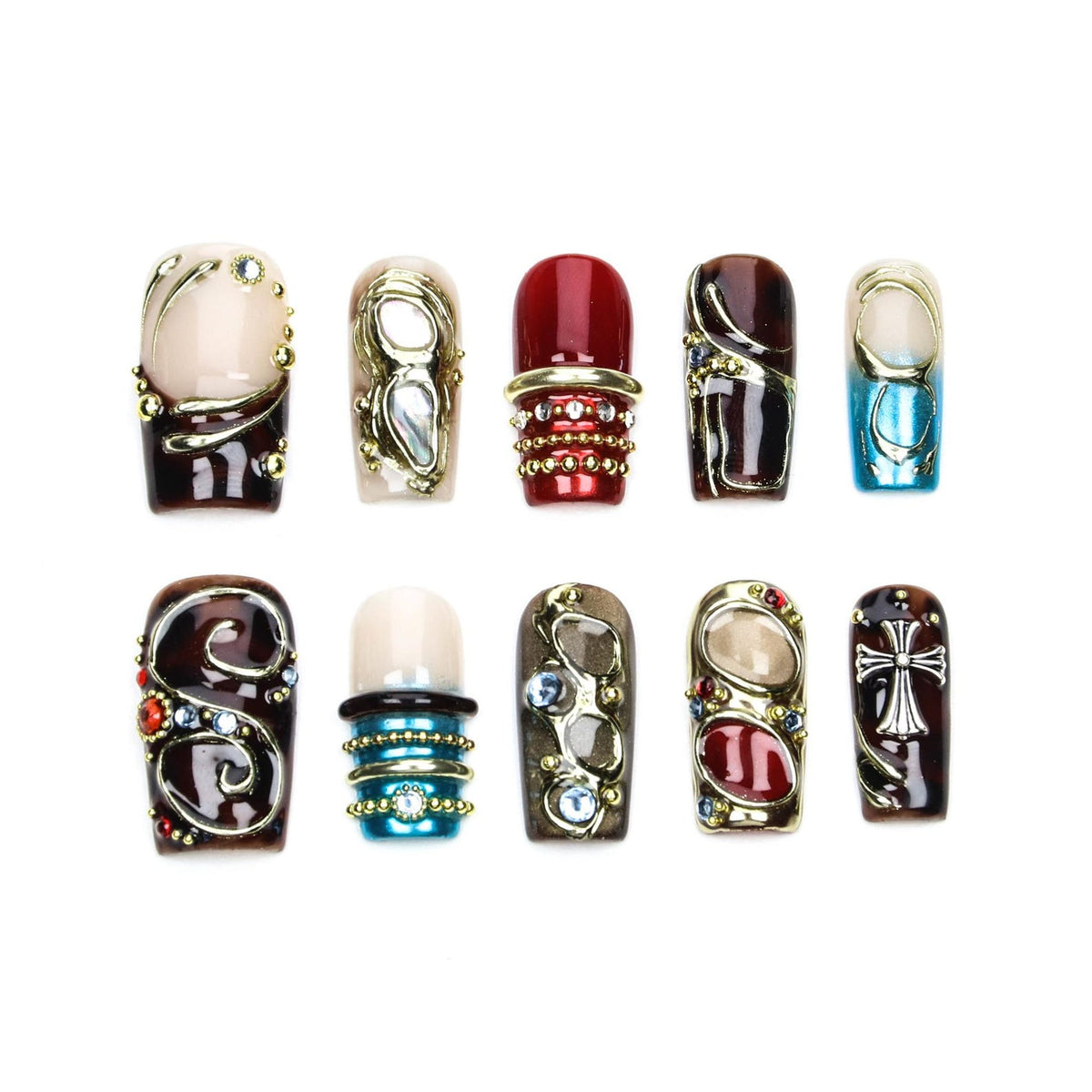A set of ten press-on nails featuring diverse designs including deep red, brown, and blue tones. The nails are decorated with metallic gold and silver accents, intricate swirls, small embedded rhinestones, and a prominent silver cross emblem.