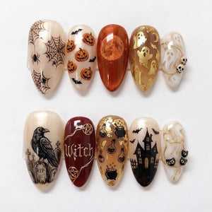A set of ten almond-shaped press-on nails featuring Halloween designs. Patterns include spider webs, jack-o'-lanterns, a metallic orange moon, gold ghosts, skulls, a raven on a tombstone, the word Witch, potions, a haunted house, and cats.