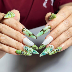 Green marble press on nails with botanical leaf art, 3D white flowers, gold chrome accents, pearl embellishments, and glossy square shape