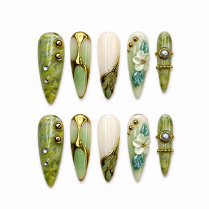Green marble press on nails with botanical leaf art, 3D white flowers, gold chrome accents, pearl embellishments, and glossy square shape