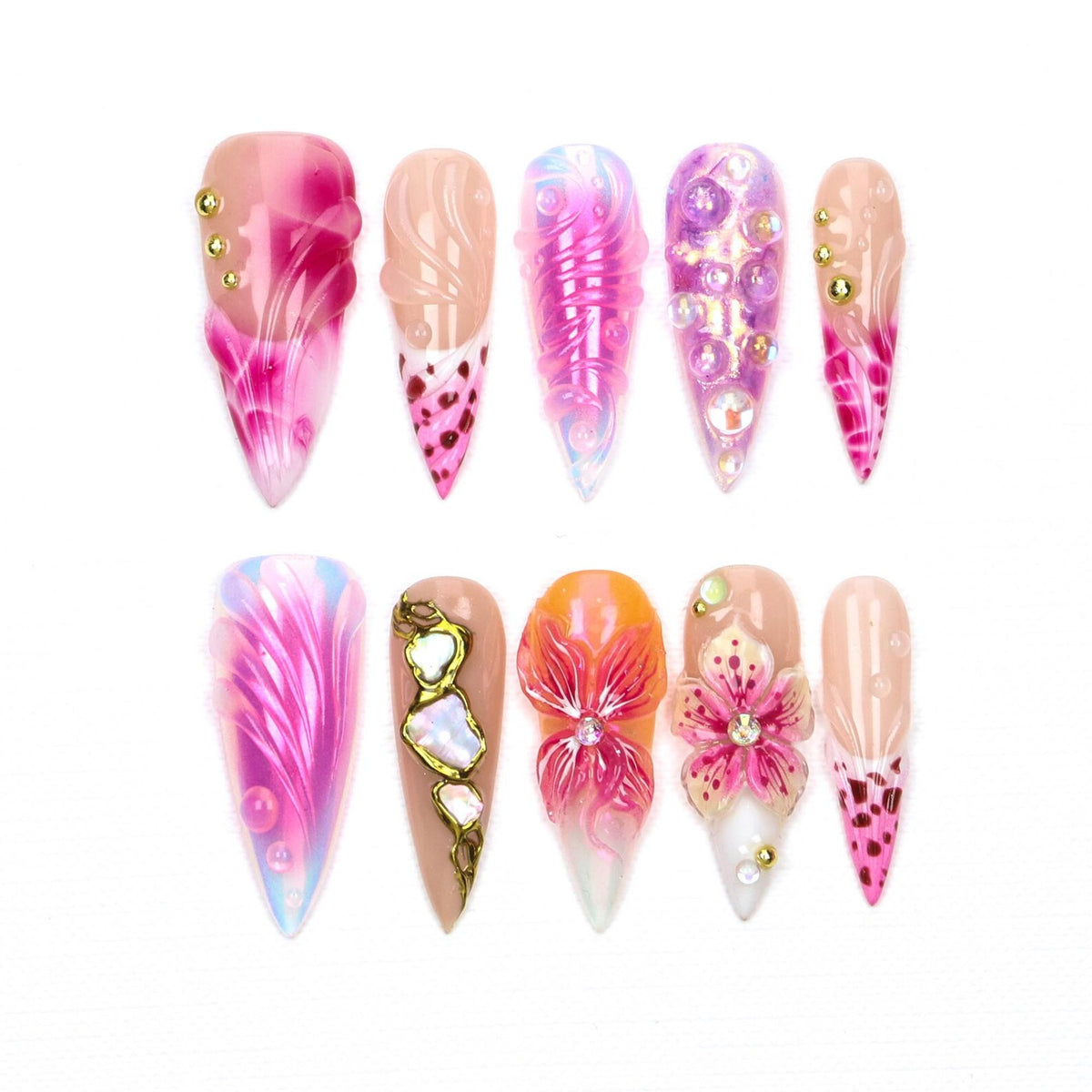 A set of ten almond-shaped press-on nails featuring various designs including pink and purple gradients, raised swirling patterns, iridescent spheres, gold studs, metallic gold accents, and hand-painted floral motifs with embedded rhinestones.