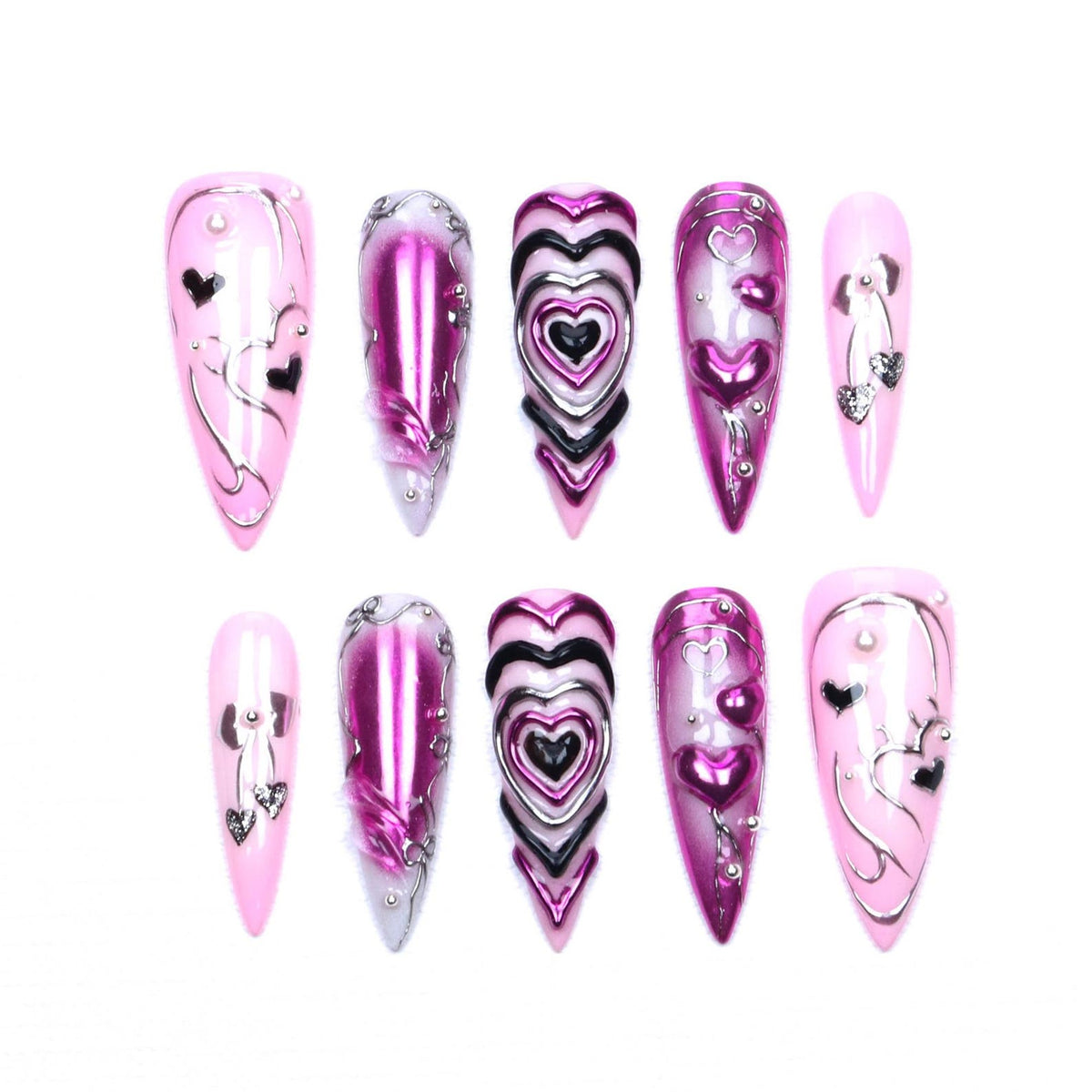 A set of ten stiletto-shaped press-on nails in shades of pink, magenta, and black. The designs feature metallic chrome finishes, raised 3D heart motifs, silver line art, and small embedded rhinestones on a glossy, smooth surface.